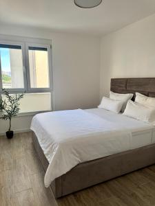 a bedroom with a large bed with white sheets and pillows at Villa Blue Lagoon in Makarska +25 photos