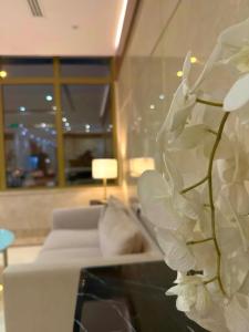 a white flower sitting on a table in a living room at اسفار بلازا للشقق المخدومة اقتصادي in Riyadh +25 photos