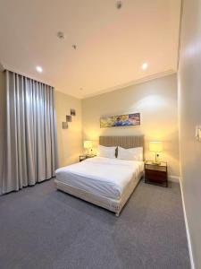 リヤドにあるAsfar Plaza Hotel & Apartmentsのベッドルーム(白いベッド1台、ランプ2つ付)