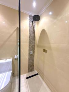 a shower with a glass door in a bathroom at Asfar Plaza Hotel & Apartments in Riyadh +28 photos