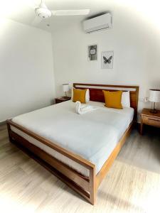 a bedroom with a large bed with yellow pillows at Modern apartament near the sea-Las Terrenas in La Iglesia +13 photos