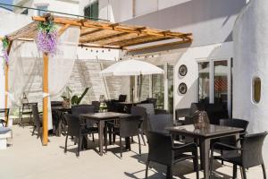 an outdoor patio with tables and chairs and an umbrella at Villa Paraíso da Caparica in Charneca