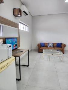a living room with a couch and a table at Flat 01 - Zona Sul Prox UMC, Praia Clube, Shopping e Pátio Vinhedos in Uberlândia