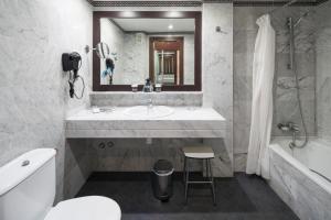
a bathroom with a sink, toilet and bathtub at Catalonia Oro Negro in Playa de las Americas
