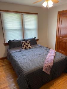 a bedroom with a large bed with a ceiling fan at Private downtown cottage in Indianapolis