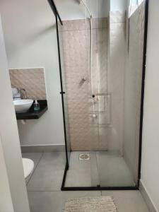 a bathroom with a shower with a toilet and a sink at Flat 01 - Zona Sul Prox UMC, Praia Clube, Shopping e Pátio Vinhedos in Uberlândia