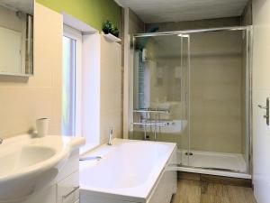 a bathroom with a tub and a sink and a shower at Sonnenterrasse & 2 King-Size DZ - Citynah & ruhig in Berlin +14 photos