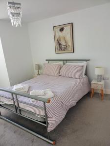 イプスウィッチにあるLuxury 2-Bed Flat Central Ipswich Parkingのベッドルーム1室(大型ベッド1台、ストライプシーツ付)