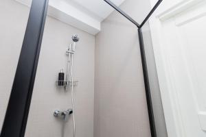 a shower with a glass door in a bathroom at 1-bedroom loft in Siena Tirgus in Rīga