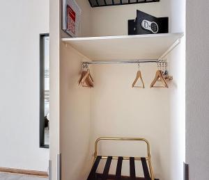 a room with a chair and a shelf with hangers at Slina Hotel Brussels in Brussels