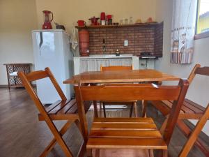 a kitchen with a table and chairs and a refrigerator at Recanto Cachoeiras de Ibicoara in Ibicoara