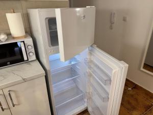 a white refrigerator with its door open in a kitchen at Julija 4 in Pančevo