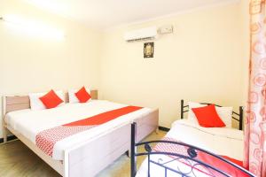 a bedroom with a bed with red pillows at Hotel O Kingston Residency in Vānivilāsa Puram +18 photos