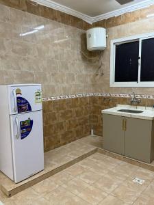 Taymāʼにあるشقق أضواء الشمال للشقق المخدومةの白い冷蔵庫とシンクのあるキッチン