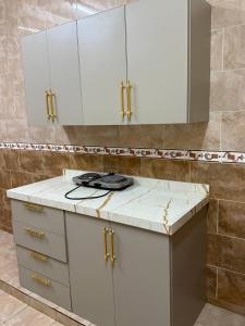 Taymāʼにあるشقق أضواء الشمال للشقق المخدومةの白いキャビネットと鏡付きのキッチン