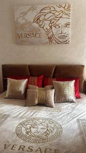 ein Bett mit roten Kissen und einem Gemälde an der Wand in der Unterkunft Bel appartement a fadaat mohit dar bouazza in Casablanca