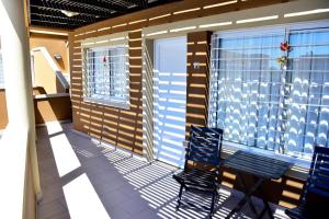 a balcony with two chairs and a window at Complejo Pircas Sol in Las Grutas