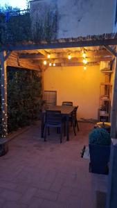 a patio with a table and chairs under a pergola at La coccinella in Castelfiorentino +12 photos
