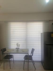 a table and chairs in a room with a window at J. B Apartamentos in Santo Domingo