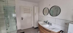 a bathroom with a sink and a shower and a mirror at Ferienhaus an der Ölmühle in Heusweiler +43 photos