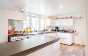 a kitchen with white cabinets and a stove at Charmant manoir Sud de Paris in Saint-Sauveur-sur-École