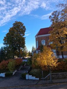 a brick building with trees in front of it at Šiluvos Svaja in Šiluva