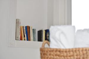 a book shelf with books on it next to a basket at Villa Sonia in Siracusa