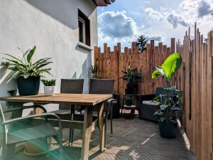 a patio with a wooden table and chairs and a fence at Sonnenterrasse & 2 King-Size DZ - Citynah & ruhig in Berlin