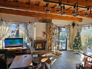 a living room with a fireplace and a christmas tree at Tri chalúpky na Mýte in Mýto pod Ďumbierom