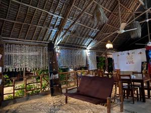 a room with a chair and a table in it at Mpole Bungalows in Michamvi
