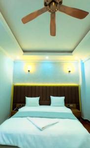Un dormitorio con una cama grande con ventilador de techo. en Hagarlawe International Hotel 2, en Jijiga