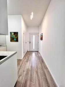 an empty kitchen with white walls and wood floors at Wohnung am Rosengarten in Kehl am Rhein +3 photos