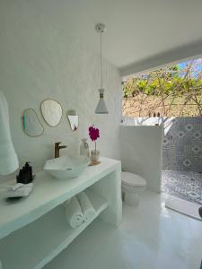 a bathroom with a sink and a toilet and mirrors at IslaVerde Hotel in La Mesa