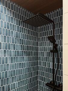 a shower in a blue tiled bathroom at Unique, newly renovated studio in Turku +17 photos