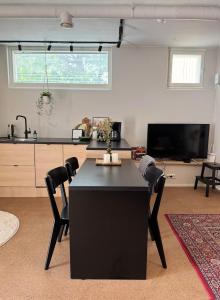sala de estar con mesa negra y sillas en Unique, newly renovated studio, en Turku