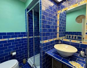 a blue tiled bathroom with a toilet and a sink at LA MAISON DU PORT - Superior Apartment, bright, glam, and refined with a wonderful sea view in Anzio city center in Anzio +33 photos