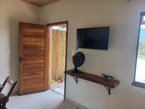 a room with a door and a television on a wall at Recanto Cachoeiras de Ibicoara in Ibicoara