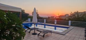 a swimming pool with two chairs and a umbrella at Finca Ca Nostra, Charmante Villa, Großzügiger Pool & Meerblick in Llucmajor