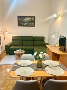 Una sala de estar con un sofá verde y una mesa. en Ana Marija Apartment - Vila Golf, en Rogaška Slatina