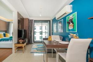 ein Wohnzimmer mit blauen Wänden und ein Esszimmer in der Unterkunft 1 Bedroom Apartment - The Aristo Resort by HCR in Ban Lum Fuang + 26 Fotos