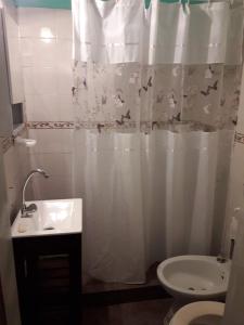 y baño con cortina de ducha, lavabo y aseo. en Departamentos Don Carlos, en Villa Cura Brochero 21 fotos más