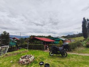 a motorcycle parked in the grass in a yard at Posada Rural Añoranza Boyacense in Paipa