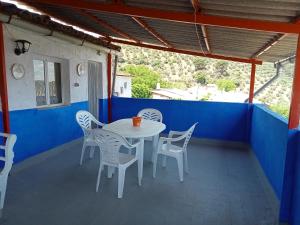 a white table and chairs on a patio at El Almendro De La Tia Teresa in Prados de Armijo
