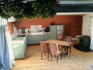 a kitchen with a wooden table and chairs at Gîte du Volcan des Causses in Saint-Jean-dʼAlcapiès