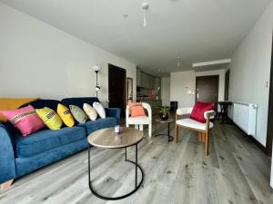 Una sala de estar con un sofá azul y sillas. en Luxury Double Bed En-Suite in London, en Barking