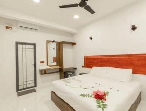 a bedroom with a bed with a flower on it at Oak Thoddoo in Toddu Atoll