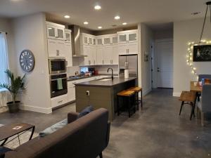 a kitchen and living room with white cabinets and a table at Actually walkable to square & Private Heated Pool in Georgetown