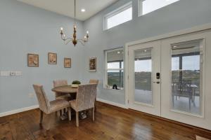 a dining room with a table and chairs and windows at Esperanza Ranch w/Hot-tub, Fire pit, Gorgeous View in Stonewall