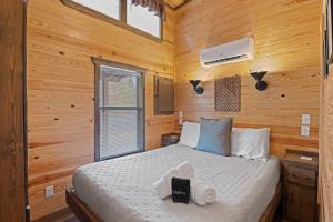 una camera da letto con un letto in una cabina di legno di All Tuckered Out - Riverfront Cabin, Fish, Hike & 5 Minutes to Sylva! a Sylva