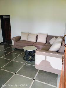 een woonkamer met een bank en een tafel bij Sukhad Home Stay in Gimvi